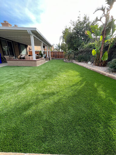 Beautiful backyard with lush green lawn and a spacious patio area, designed by AtoZ Construction, perfect for outdoor living and entertaining.